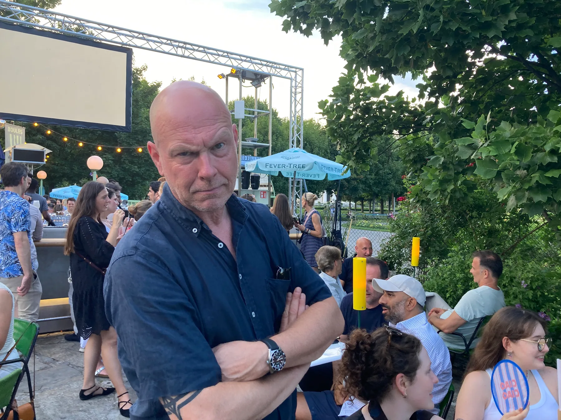 Ein Kollege posiert mit verschränkten Armen beim After Work im Volksgarten