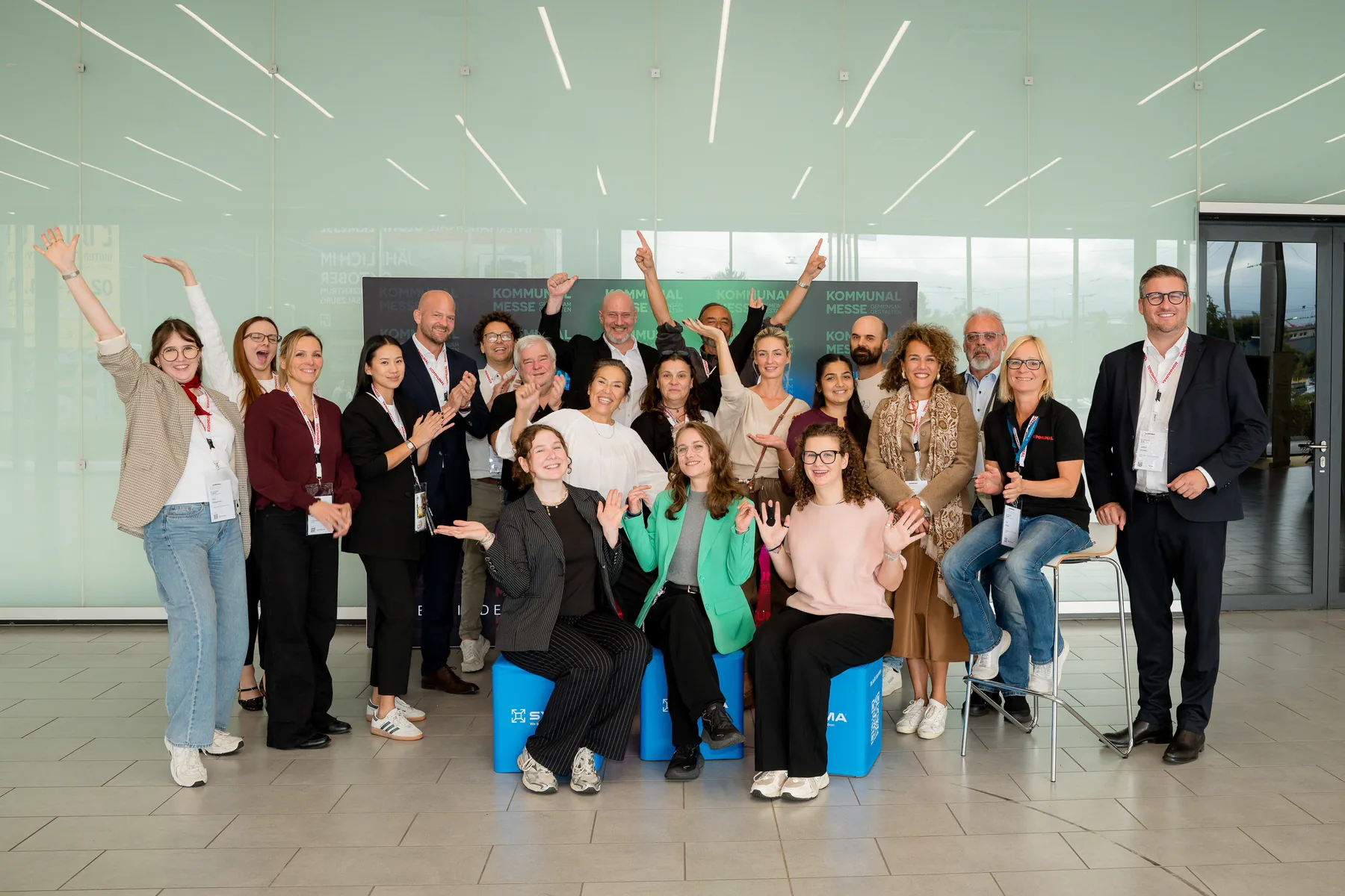 Gruppenfoto des Teams mit erhobenen Armen auf der KOMMUNAL Messe 2026 in Salzburg